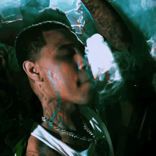a man with a tattoo on his neck is smoking a cigarette in front of a crowd