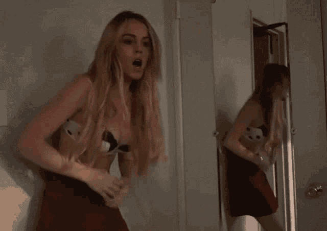a woman in a bra is standing in a room .