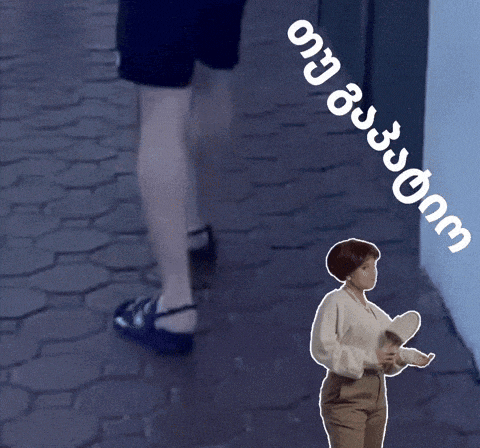 a woman is standing on a sidewalk next to a sign that says ' georgia ' on it
