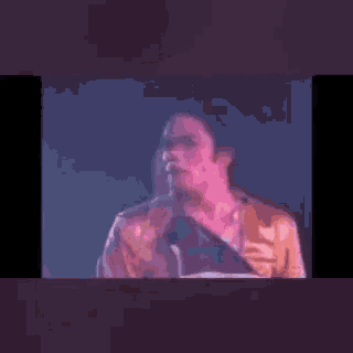 a close up of a man standing in front of a microphone .