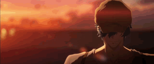 a man in a hat stands in front of a sunset sky