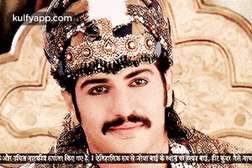 a man wearing a crown and a mustache is sitting on a bed .