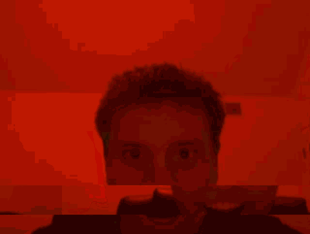 a man is smiling in a red background