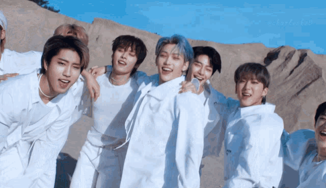 a group of young men in white are posing for a photo