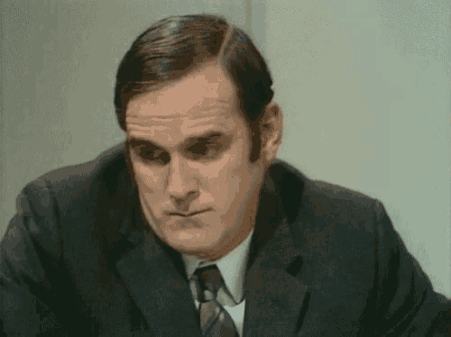 a man in a suit and tie looks at the camera