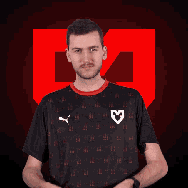 a man wearing a black shirt with the letter m on the front