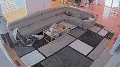a living room with a large sectional couch , coffee table , and rug .