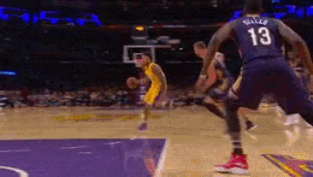 a basketball player with the number 13 on his back dribbles the ball