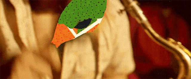 a person playing a saxophone with a green and orange bird on their shirt