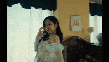a woman is talking on a phone in front of a calendar that says 30 on it
