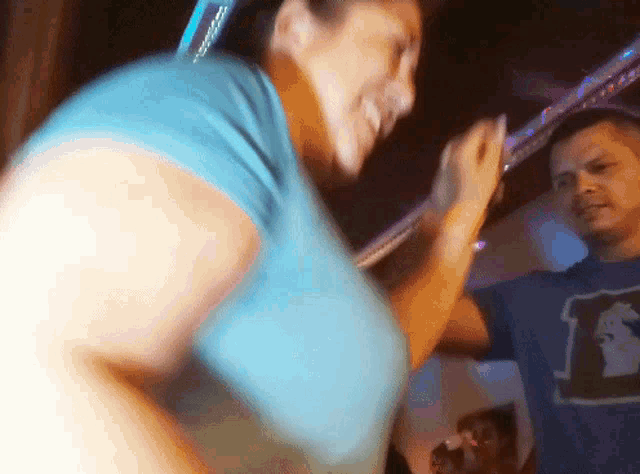 a woman in a blue shirt is dancing with a man in a blue shirt with the number 1 on it