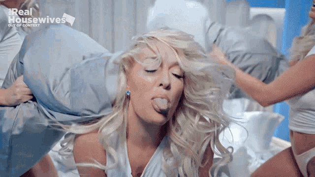 a woman is sticking her tongue out in front of a real housewives logo