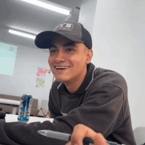 a man wearing a hat with the letter s on it smiles