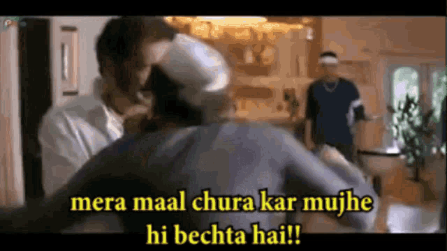 a group of men are standing in a room and one of them is saying mera maal chura kar mujhe hi bechta hai .