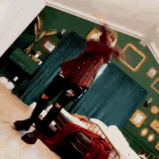 a person is standing in a room with a green wall and a couch .