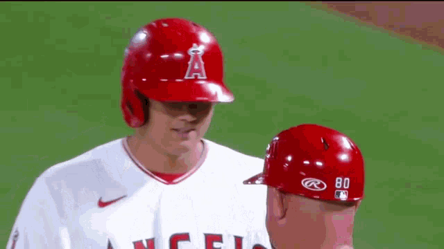 two baseball players are talking to each other on the field