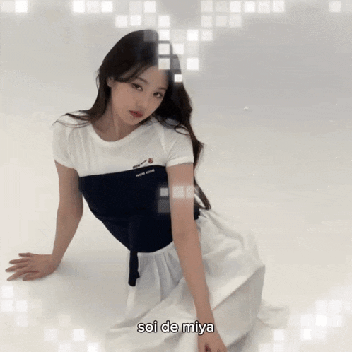a girl in a white dress is kneeling down with the words soi de miya written below her