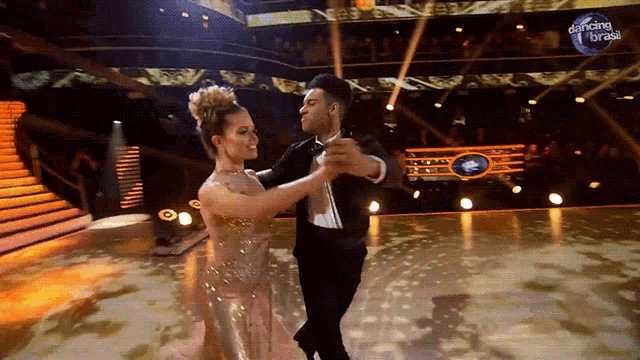 a man and woman are dancing in front of a dancing brasil sign