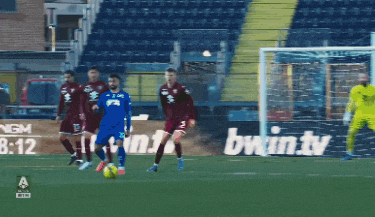 a group of soccer players on a field with an ad for bwin.tv in the background