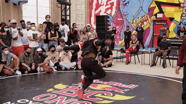 a man dancing in front of a crowd with a red bull logo
