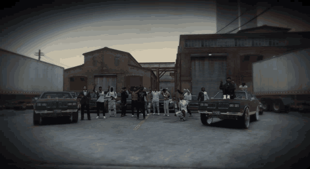 a group of people are posing for a picture in a parking lot with a bmw on the right