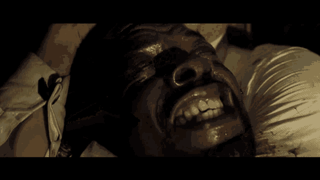 a man with blood on his face is smiling