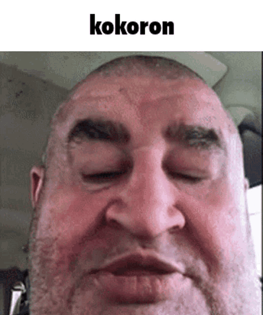 a close up of a man 's face with his eyes closed and the word kokoron written above him .