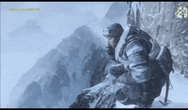 a man in a military uniform is kneeling down on a snow covered mountain