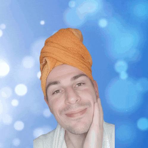 a man with a towel wrapped around his head is smiling for the camera