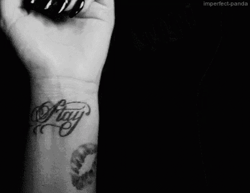 a black and white photo of a person 's wrist with a tattoo that says ' imperfect panda '