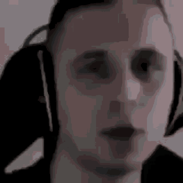 a man is wearing headphones and looking at the camera .