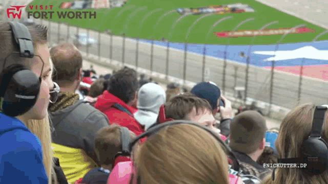 a crowd of people watching a race with the words visit fort worth on the top