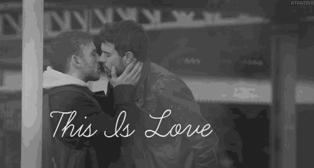 a black and white photo of two men kissing with the words this is love below them