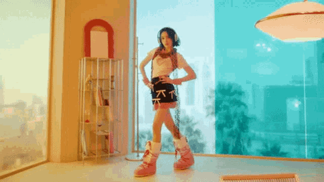 a woman is dancing in a room with a mirror and a window