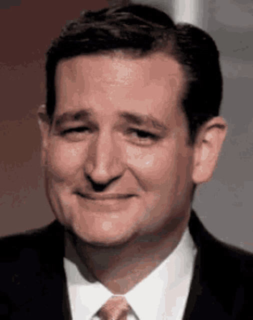 a man in a suit and tie is smiling with his eyes closed .