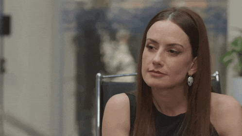 a woman is sitting in a chair with her eyes closed