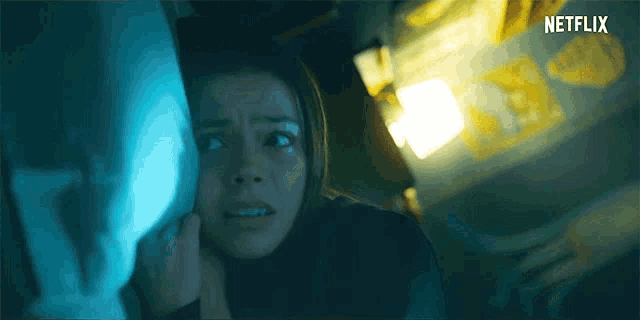 a woman in a dark room with a netflix logo on the bottom