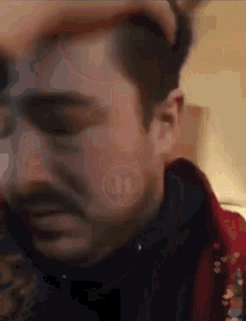 a close up of a man 's face with the letters tp on the bottom