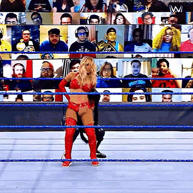 a woman in a red outfit is in a wrestling ring with a crowd watching