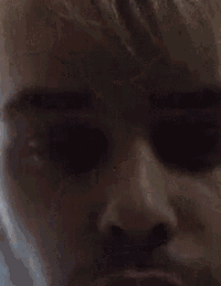 a close up of a person 's face with a beard and a very dark eye .