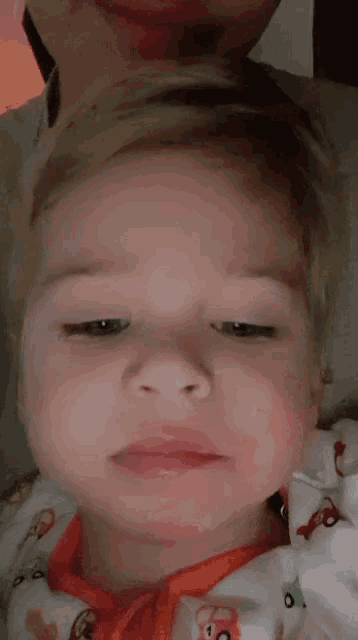 a close up of a baby 's face with a man 's face in the background