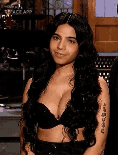 a woman with long hair and a tattoo on her arm is wearing a bra .