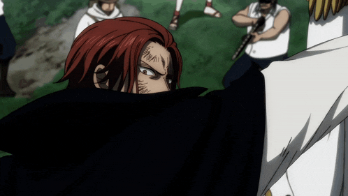 a man with red hair and a scar on his face stands in front of a group of people