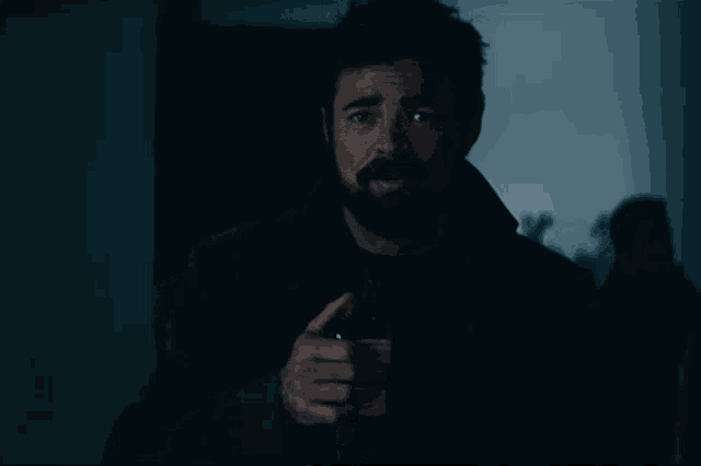 a man with a beard holds a gun in his hand