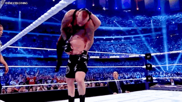 a man in a wrestling ring is being lifted by another man