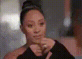 a woman in a black dress is making a funny face while holding her hand to her chin .