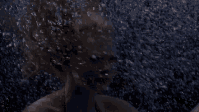 a woman is swimming in the water with bubbles coming out of her face