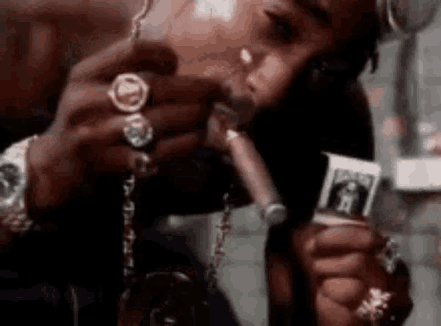 a man is smoking a cigar and holding a piece of money in his hand .