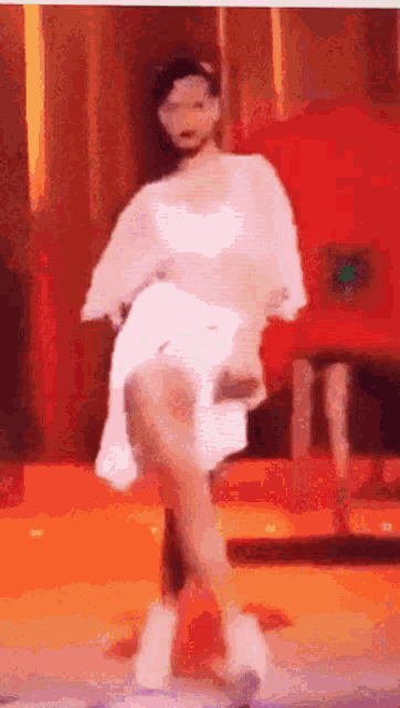 a woman in a white dress is dancing on stage