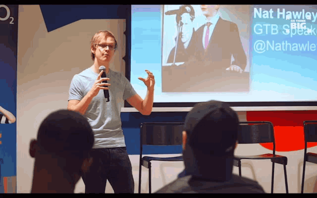 a man giving a presentation with the name nat hawley on it